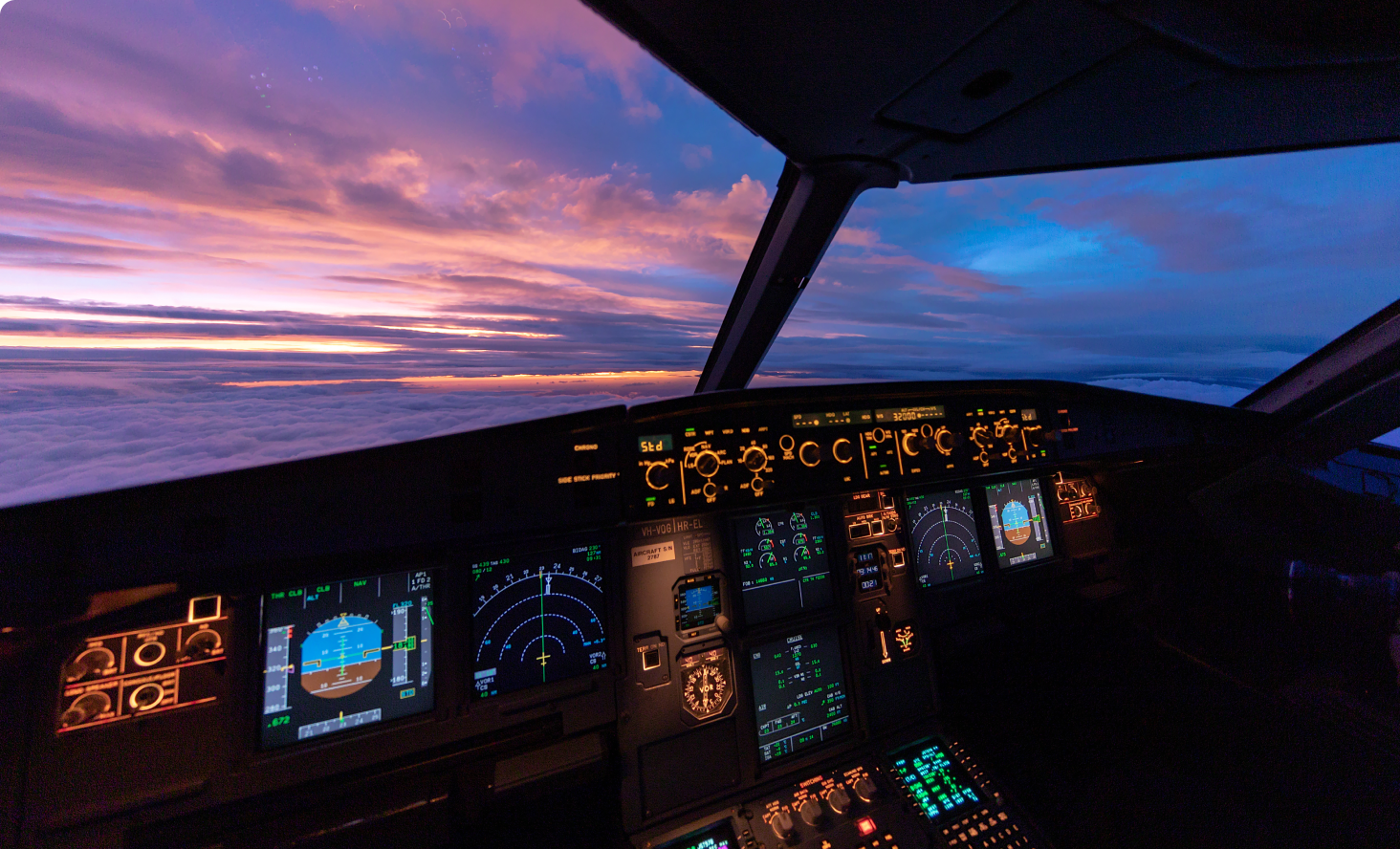 Image from inside an airplane cockpit overlooking a sunrise